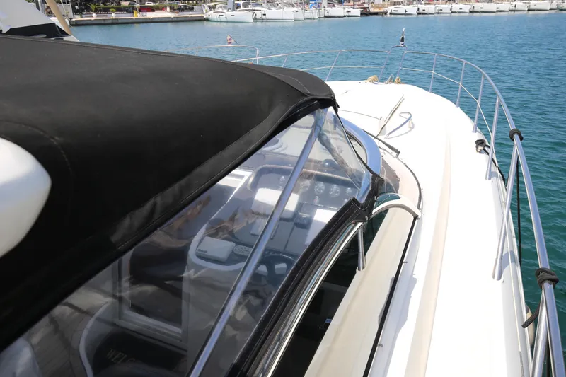  Yacht Photos Pics 2001 Sunseeker Camargue 50 yacht with black canopy, docked in a marina.