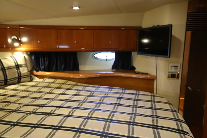  Yacht Photos Pics Luxurious cabin interior of 2001 Sunseeker Camargue 50 yacht with plaid bedding and TV.