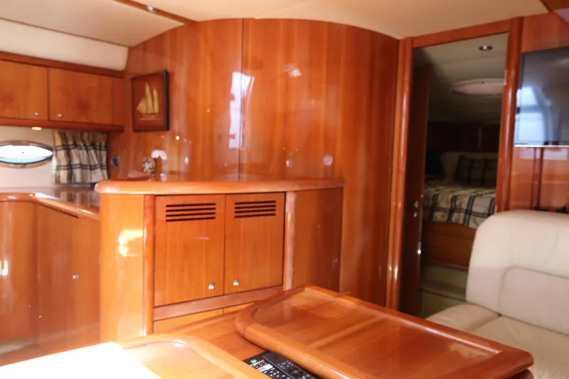  Yacht Photos Pics Interior of 2001 Sunseeker Camargue 50 yacht with wooden cabinetry and cozy seating area.