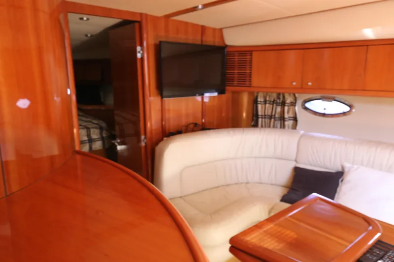 Yacht Photos Pics Interior of 2001 Sunseeker Camargue 50 yacht with wood paneling and white leather seating.