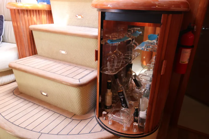  Yacht Photos Pics Luxurious interior of 2001 Sunseeker Camargue 50 yacht with glassware cabinet and wooden steps.