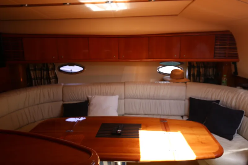 Yacht Photos Pics Interior of 2001 Sunseeker Camargue 50 yacht with plush seating and wooden table.