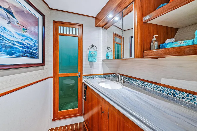 Reel Devocean Yacht Photos Pics 1990 Monterey Custom Sportfish bathroom with modern sink, wooden cabinetry, and nautical decor.