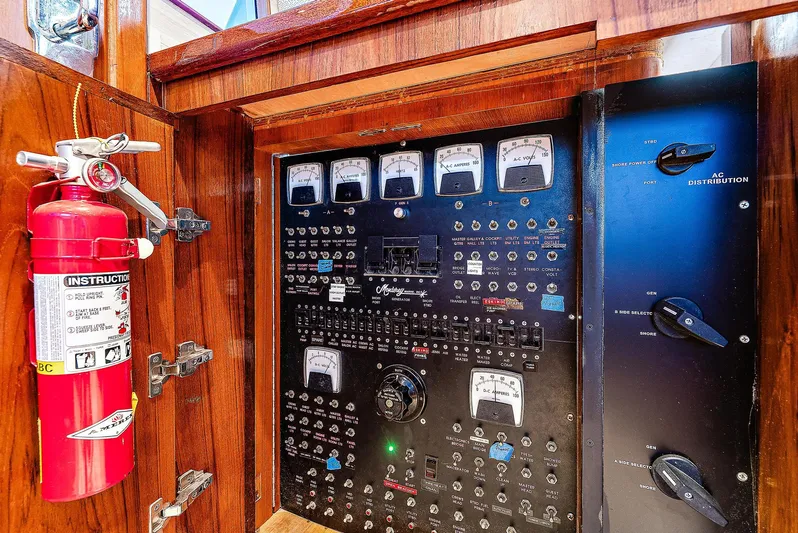 Reel Devocean Yacht Photos Pics Electrical control panel of a 1990 Monterey Custom Sportfish boat with a fire extinguisher.