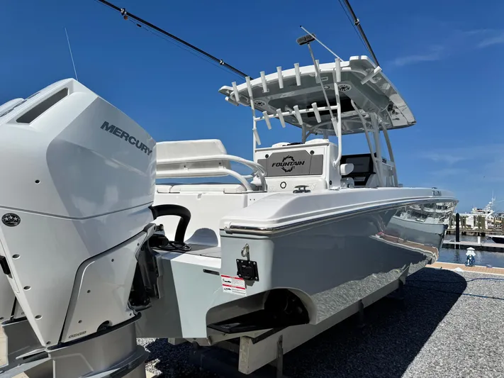  Yacht Photos Pics 2025 Fountain 34 TE boat with Mercury engine, docked under clear blue sky.