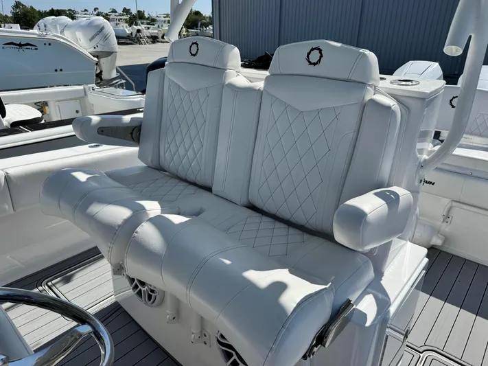  Yacht Photos Pics Luxurious white seating on 2025 Fountain 34 TE boat, featuring diamond stitching and armrests.