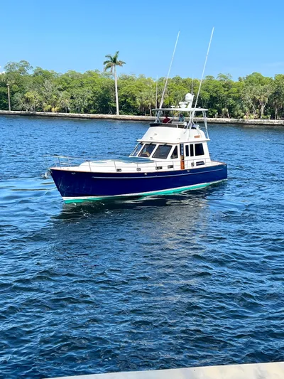 Edmond Dantes Yacht Photos Pics 2004 Legacy Downeast boat cruising on a sunny day in a scenic waterway.