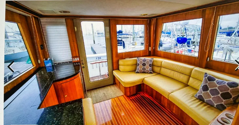 Edmond Dantes Yacht Photos Pics Luxurious 2004 Legacy Downeast yacht interior with leather seating and marina view.