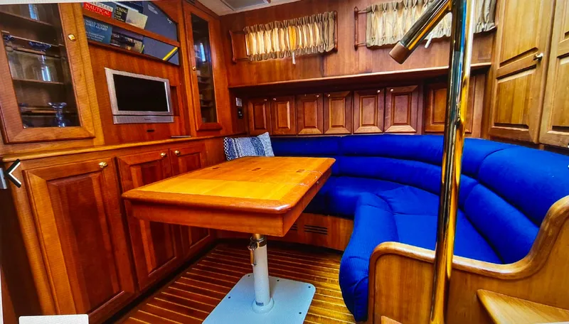 Edmond Dantes Yacht Photos Pics 2004 Legacy Downeast yacht interior with blue seating, wooden table, and cabinetry.