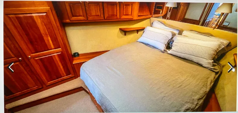 Edmond Dantes Yacht Photos Pics Luxurious 2004 Legacy Downeast yacht bedroom with wooden cabinetry and cozy bedding.
