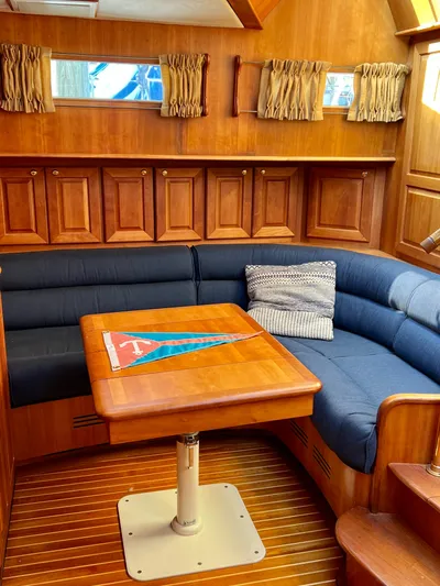 Edmond Dantes Yacht Photos Pics 2004 Legacy Downeast yacht interior with wooden paneling and blue cushioned seating.