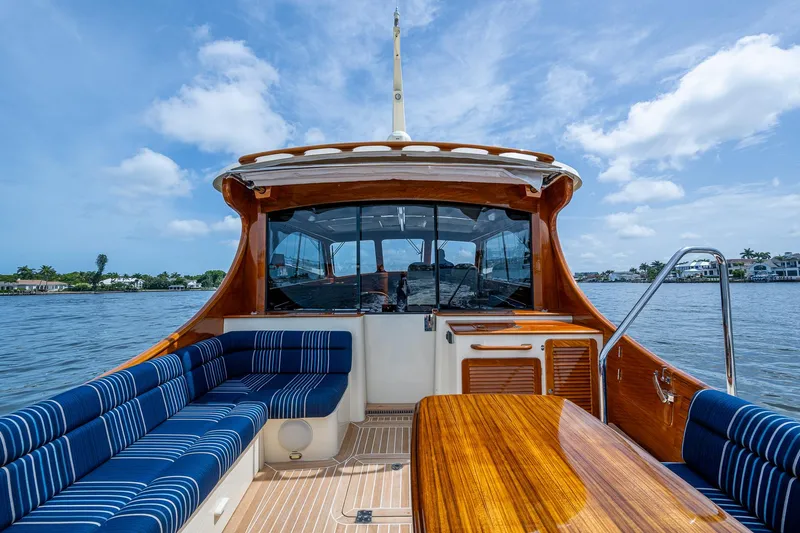  Yacht Photos Pics 2021 Hinckley Talaria 43 Motoryacht with elegant wood finish and blue seating on open water.