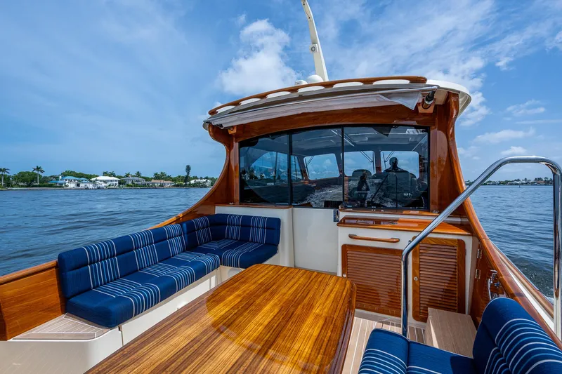  Yacht Photos Pics 2021 Hinckley Talaria 43 Motoryacht with elegant wood finish and blue seating on open water.