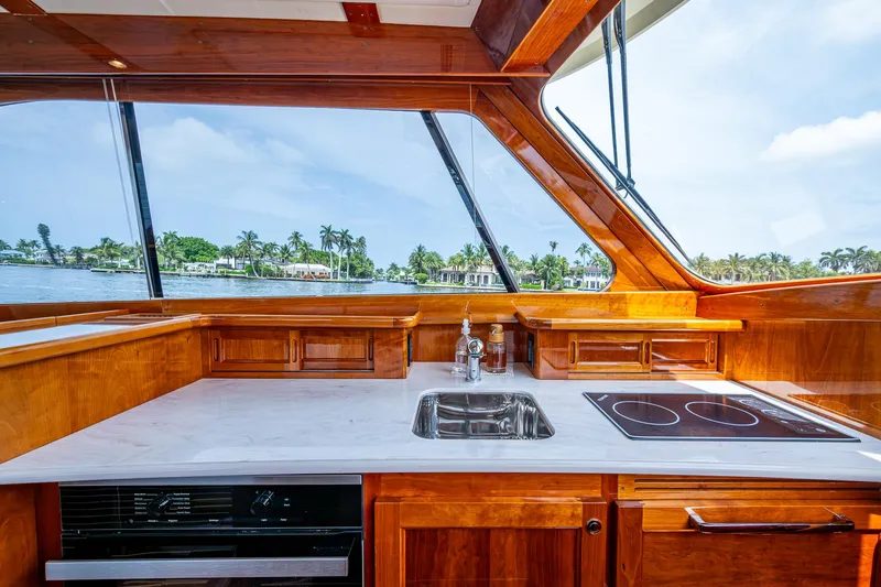  Yacht Photos Pics Luxurious 2021 Hinckley Talaria 43 Motoryacht kitchen with sleek wood finish and modern appliances.