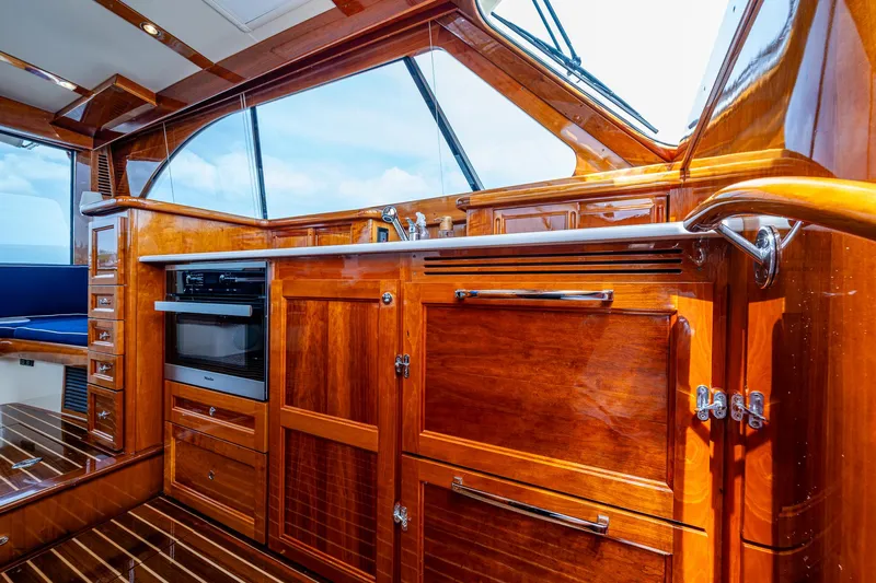  Yacht Photos Pics Luxurious interior of 2021 Hinckley Talaria 43 Motoryacht with polished wood cabinetry.