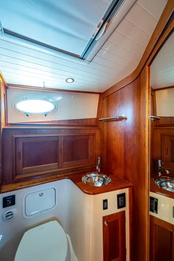  Yacht Photos Pics Hinckley Talaria 43 Motoryacht 2021 bathroom with wood cabinetry and stainless steel sink.