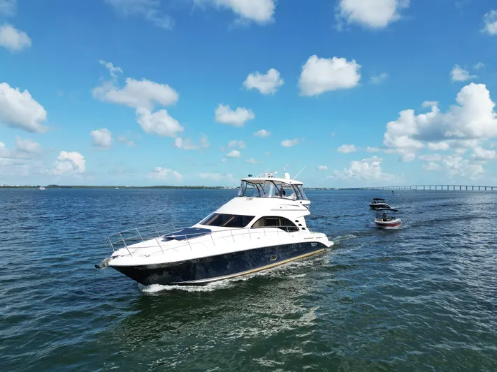  Yacht Photos Pics 2005 Sea Ray 58 Sedan Bridge yacht cruising on open water under a clear blue sky.