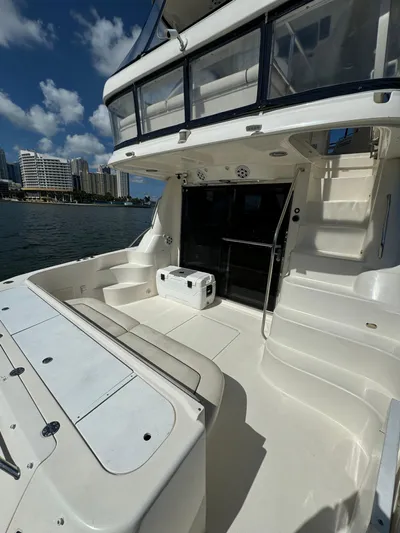  Yacht Photos Pics 2005 Sea Ray 58 Sedan Bridge yacht deck with seating, city skyline in background.