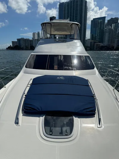  Yacht Photos Pics 2005 Sea Ray 58 Sedan Bridge yacht on water with city skyline backdrop.