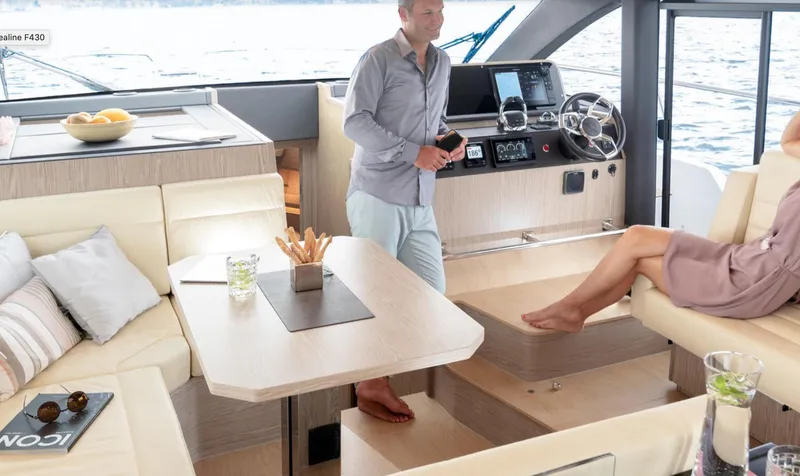  Yacht Photos Pics 2024 Sealine F430 yacht interior with modern seating, dining area, and helm station.