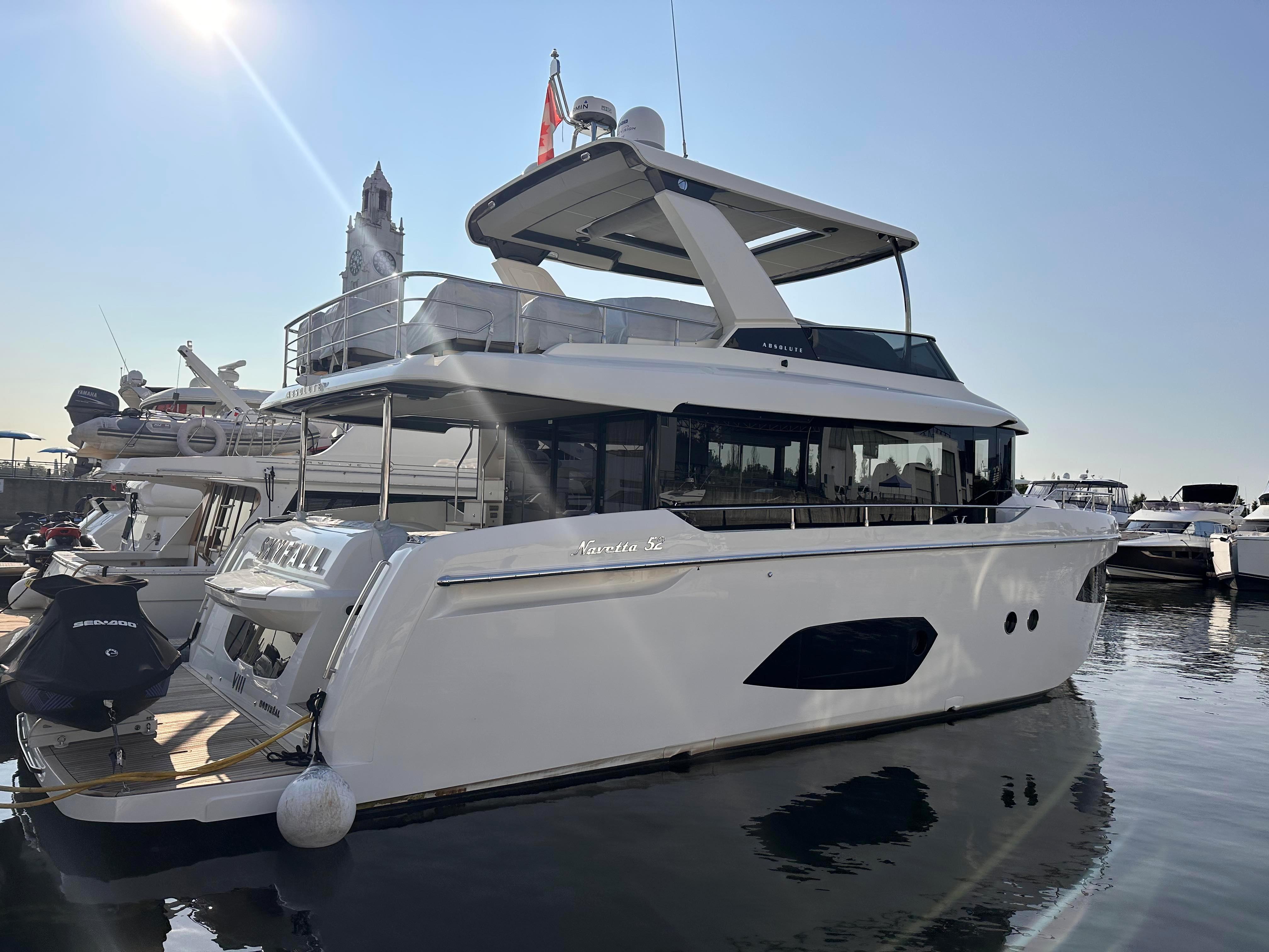 Luxury yacht Absolute 52 Navetta 2022 docked in sunny harbor.