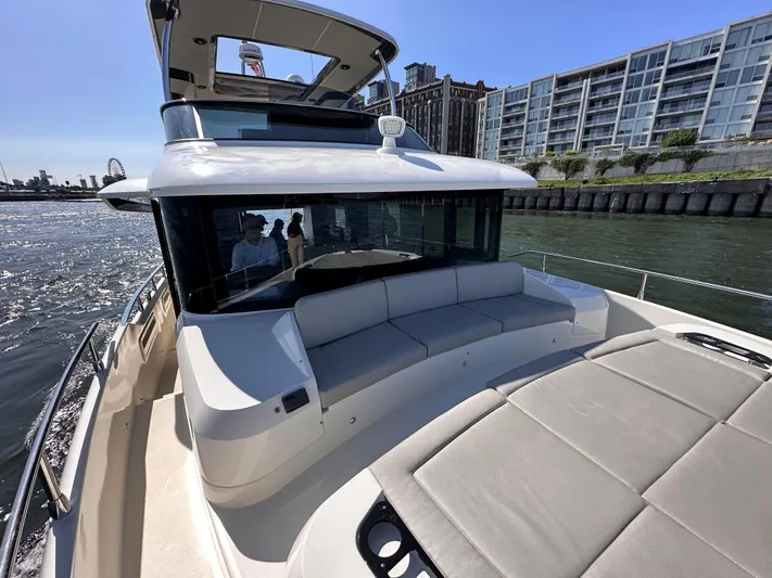 Skyfall Yacht Photos Pics Absolute 52 Navetta 2022 yacht on calm water near modern architecture.