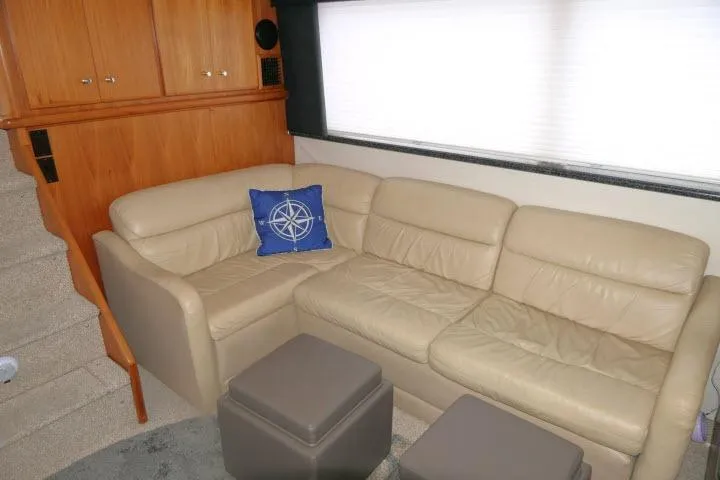 Code Four Yacht Photos Pics Interior of 2000 Carver 406 Motor Yacht with beige leather sofa and nautical-themed pillow.
