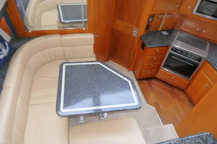 Code Four Yacht Photos Pics Interior of 2000 Carver 406 Motor Yacht with dining area and kitchen amenities.