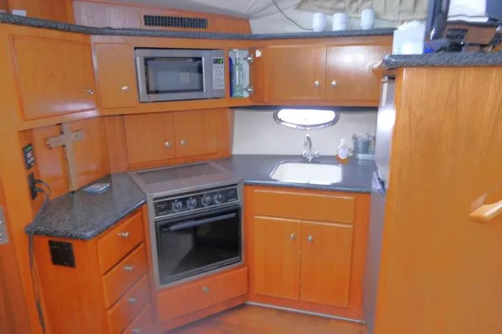 Code Four Yacht Photos Pics Kitchen area of 2000 Carver 406 Motor Yacht with wood cabinetry and modern appliances.