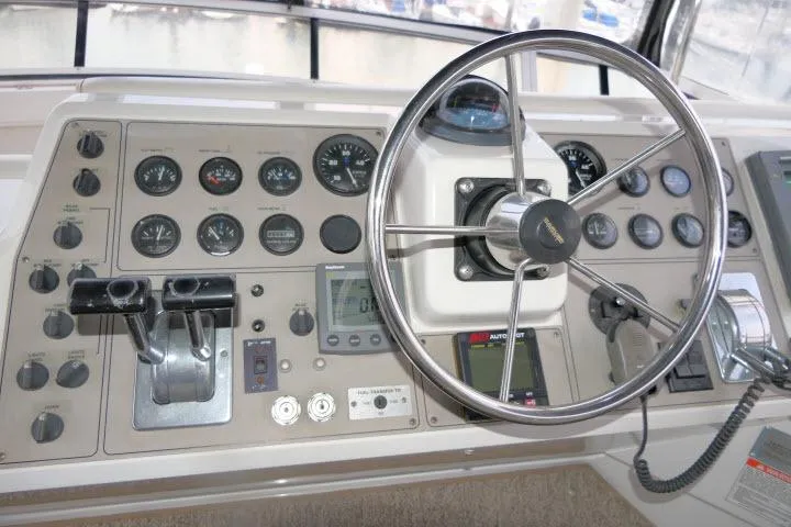 Code Four Yacht Photos Pics Control panel of a 2000 Carver 406 Motor Yacht with steering wheel and gauges.