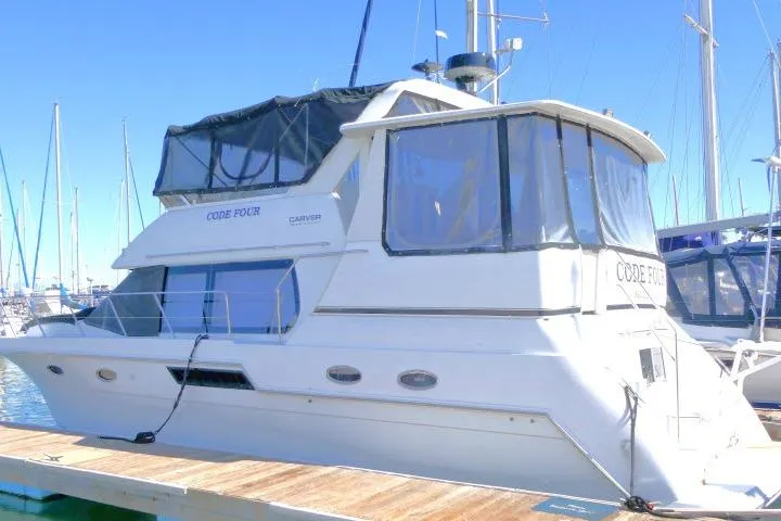 Code Four Yacht Photos Pics 2000 Carver 406 Motor Yacht docked at marina under clear blue sky.