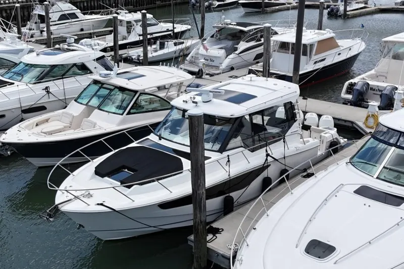  Yacht Photos Pics 2021 Boston Whaler 405 Conquest docked among other boats in a marina.