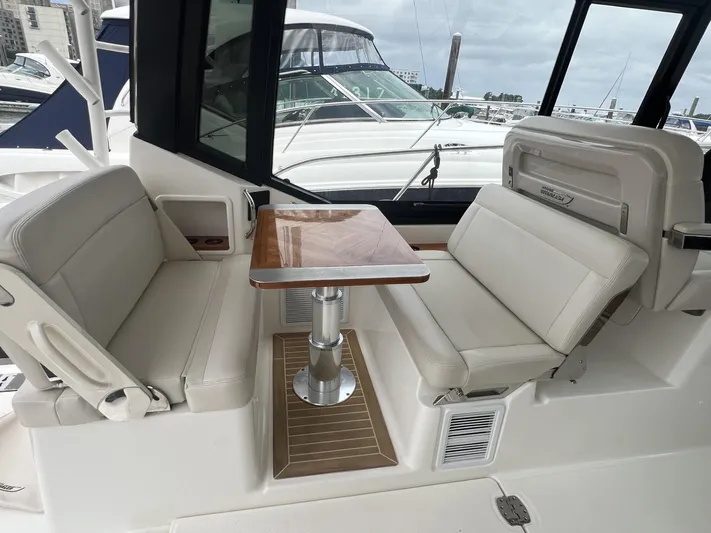  Yacht Photos Pics Boston Whaler 405 Conquest 2021 interior seating with table, docked at marina.