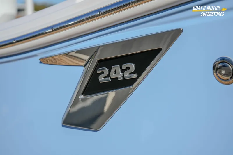  Yacht Photos Pics Close-up of 2025 Blackfin 242 HB boat emblem on light blue hull.