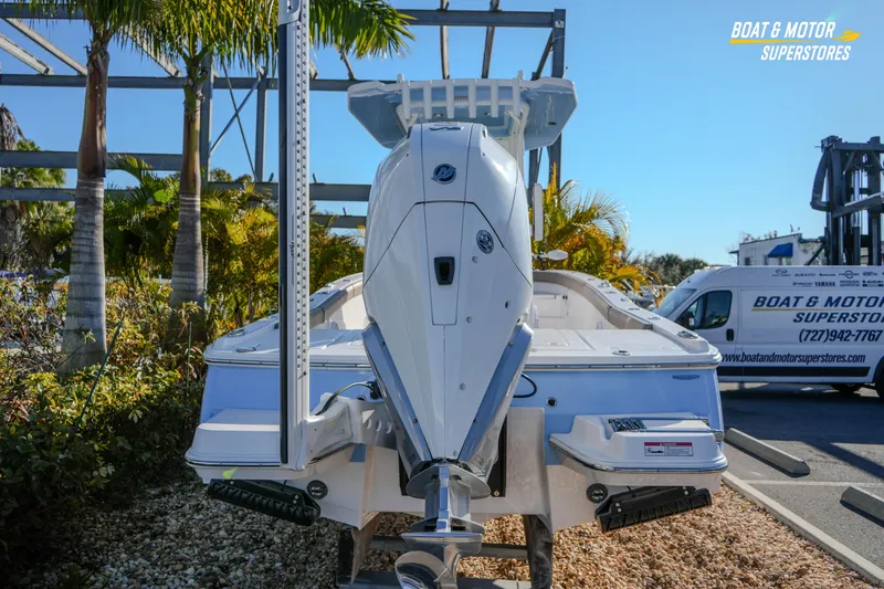  Yacht Photos Pics 2025 Blackfin 242 HB boat displayed at dealership with palm trees and van in background.