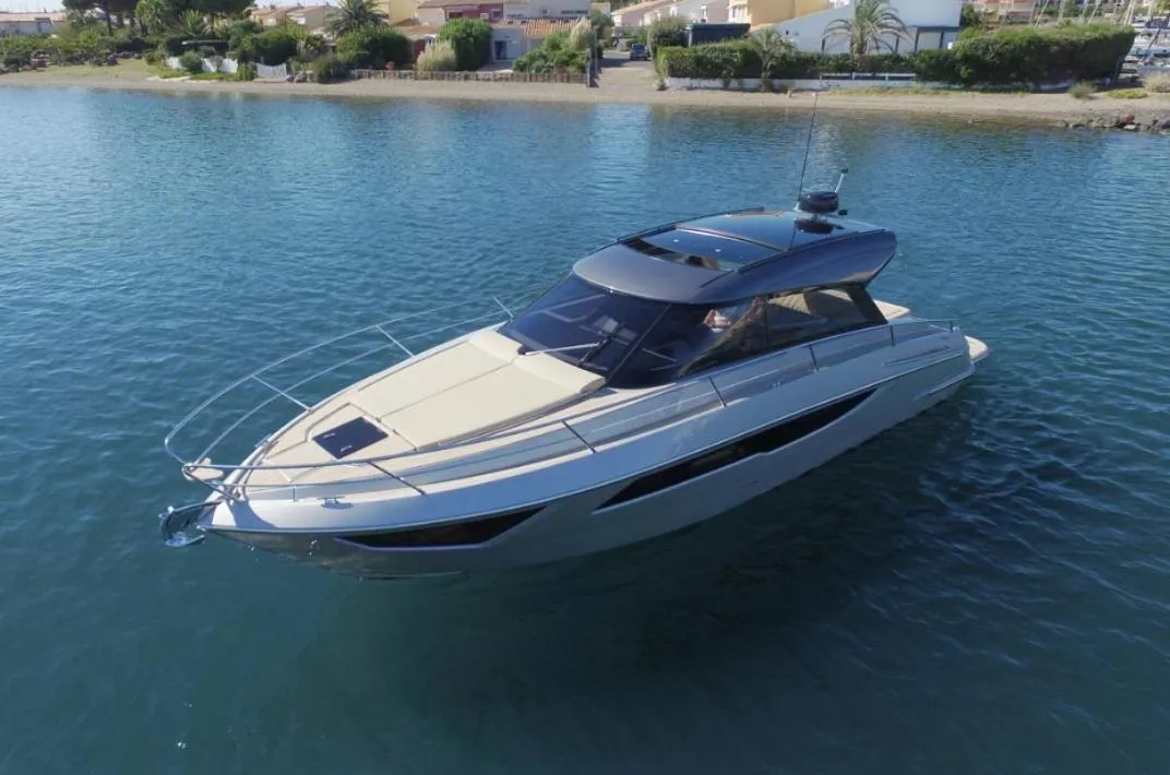 2025 Focus Power 36 yacht cruising on calm waters near a coastal area.