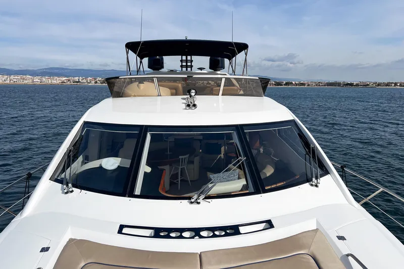  Yacht Photos Pics 2007 Sunseeker Manhattan 66 yacht on calm waters, cityscape in background.
