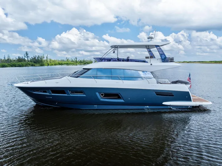  Yacht Photos Pics 2017 Prestige 560 Flybridge yacht cruising on calm waters under a partly cloudy sky.