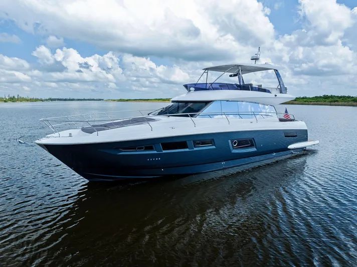  Yacht Photos Pics 2017 Prestige 560 Flybridge yacht cruising on calm waters under a cloudy sky.