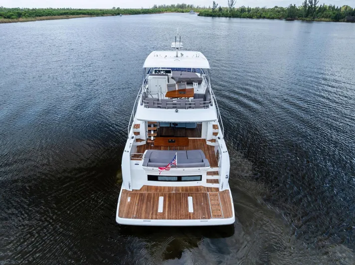  Yacht Photos Pics 2017 Prestige 560 Flybridge yacht on calm water, rear view.