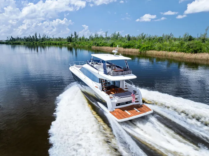  Yacht Photos Pics Prestige 560 Flybridge yacht cruising on a serene waterway, 2017 model.