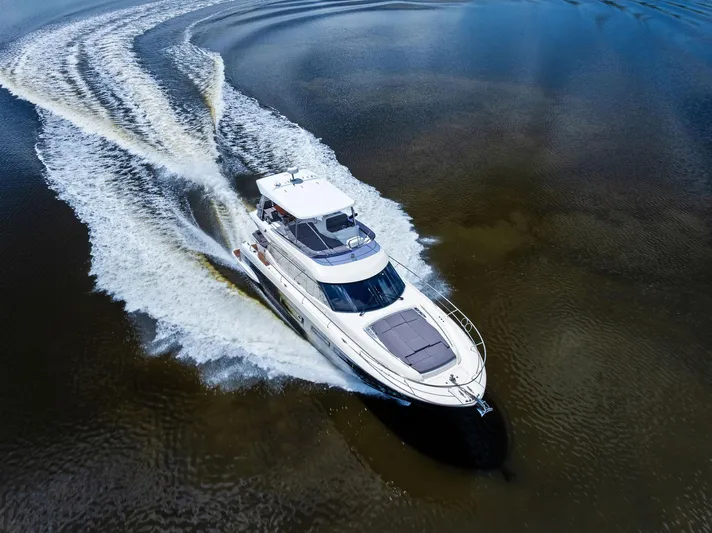 Yacht Photos Pics 2017 Prestige 560 Flybridge yacht cruising on open water, aerial view.