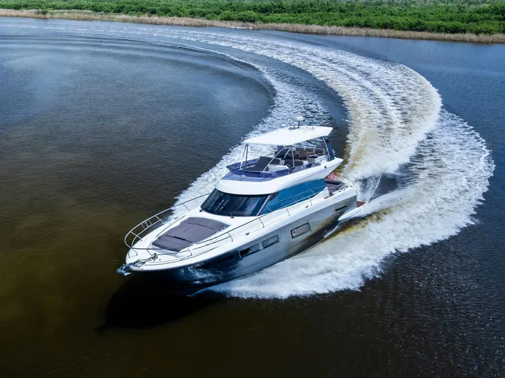  Yacht Photos Pics 2017 Prestige 560 Flybridge yacht making a sharp turn on a calm river.