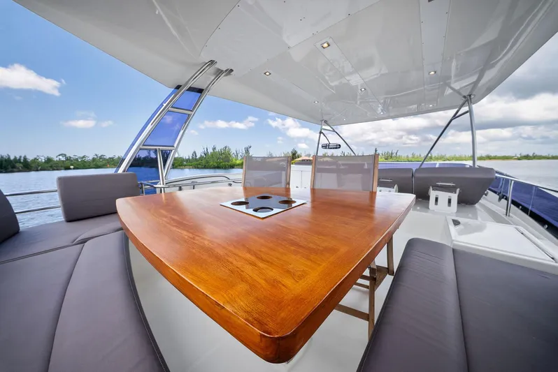  Yacht Photos Pics Prestige 560 Flybridge 2017 yacht with elegant outdoor seating and wooden table.