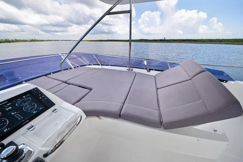  Yacht Photos Pics Prestige 560 Flybridge 2017 yacht with luxurious seating and control panel, overlooking serene waters.