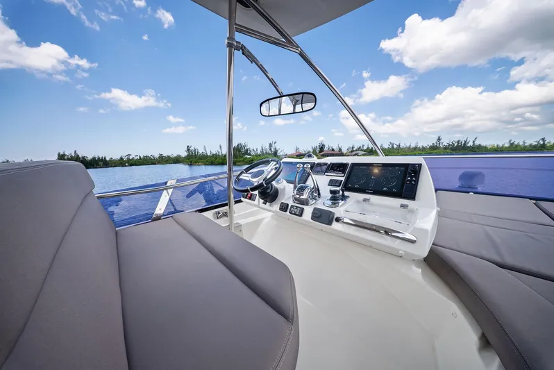  Yacht Photos Pics 2017 Prestige 560 Flybridge helm with modern controls, overlooking serene water and blue sky.