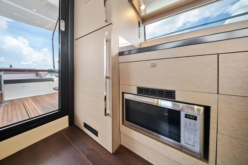  Yacht Photos Pics Modern kitchen interior on 2017 Prestige 560 Flybridge yacht, featuring sleek cabinetry and microwave.