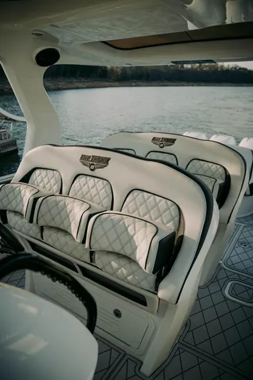  Yacht Photos Pics Luxury seating on 2021 Deep Impact 399 Sport boat with quilted upholstery, overlooking serene water.