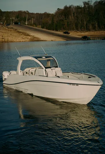  Yacht Photos Pics 2021 Deep Impact 399 Sport boat on calm water near a shoreline.
