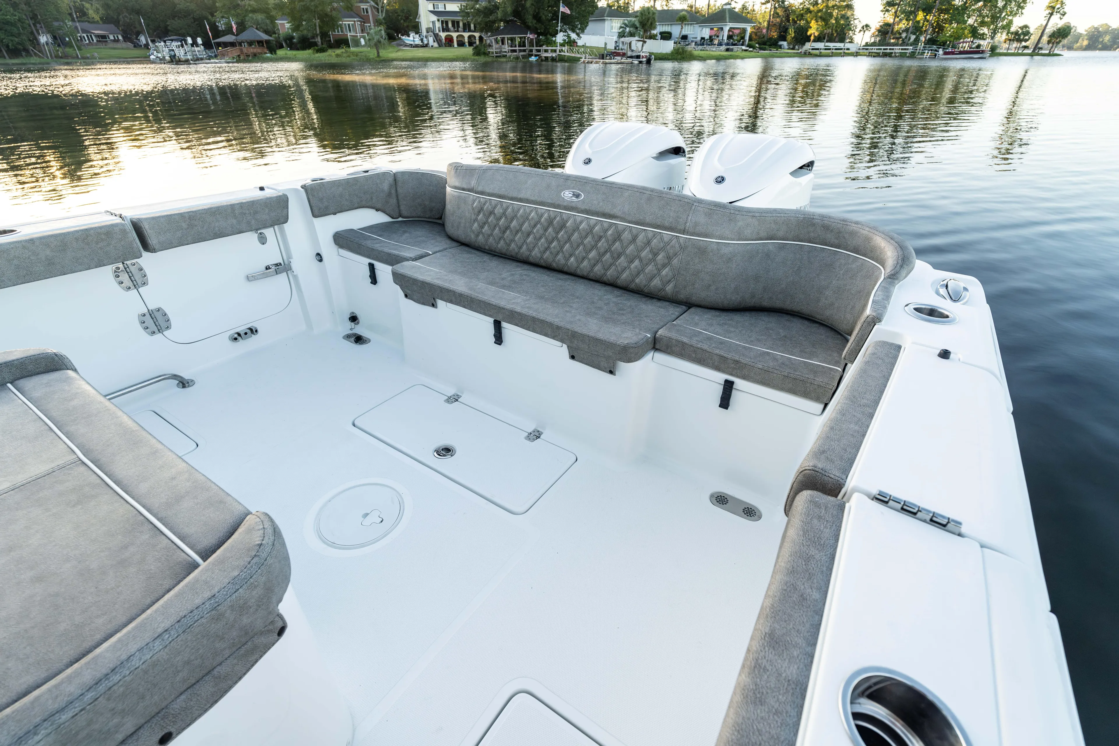  Yacht Photos Pics 2026 Sea Hunt Ultra 305 Coffin Box boat interior with cushioned seating, on a serene lake.